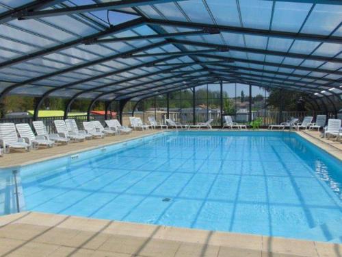 a large swimming pool with a retractable roof at Mobil home 5 pers à Avrillé avec terrasse - API-1-52-587 in Avrillé