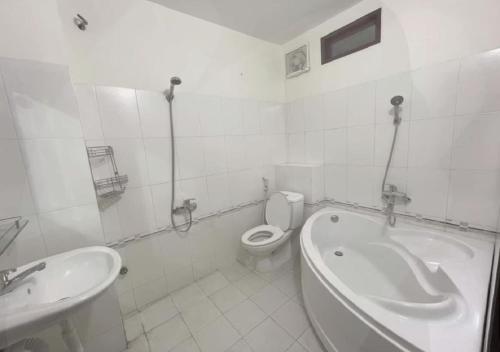 a bathroom with a tub and a toilet and a sink at Cozy Dormitory House in Da Nang