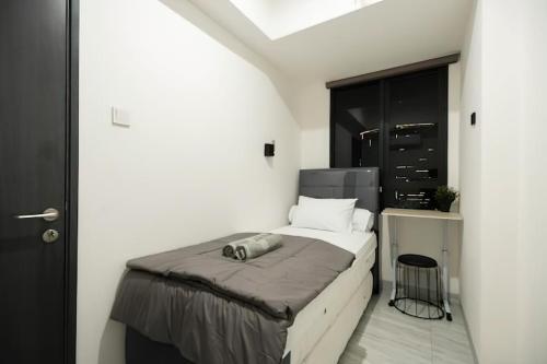 a bedroom with a bed in a white room at Premium Collins Boulevard Near Airport in Pakulonan Tiga