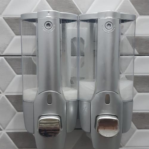 a pair of stainless steel urinals on a wall at The Carik Homestay in Tabanan