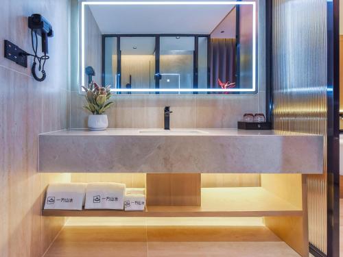 a bathroom with a sink and a mirror at Lux CABINS一方山水 in Guilin