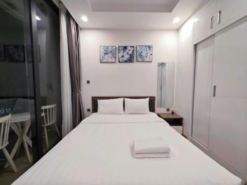 a bedroom with a large white bed with two pillows at Luxury Studio In Vinhomes Green Bay, 25' to Airport, Gym, Swimming Pools in Hanoi
