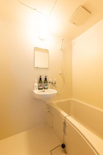 a bathroom with a sink and a bath tub at 大和の宿 Kitabukuro202 in Nara