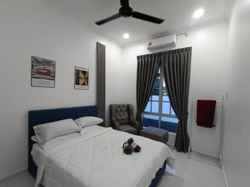 a bedroom with a bed and a ceiling fan at Homestay AGM in Mersing