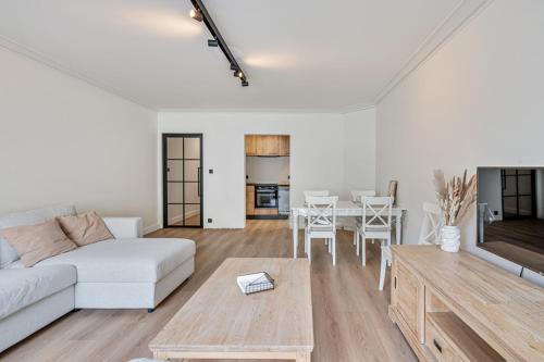 a living room with a white couch and a table at Casa Améo in Ostend