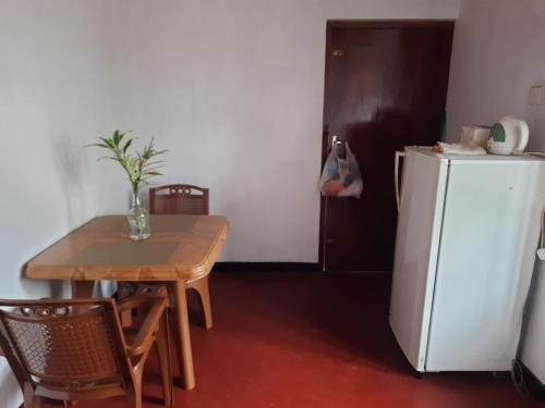 une cuisine avec une table et un réfrigérateur blanc dans l'établissement KoKo HomeStay-Weligama Apartment & Private Room, à Walliwala East