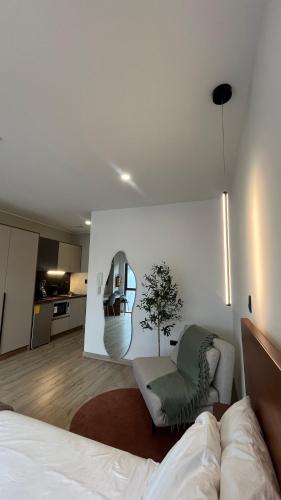 a room with a bed and a chair and a kitchen at Apartamento de Lujo en Quito in Quito