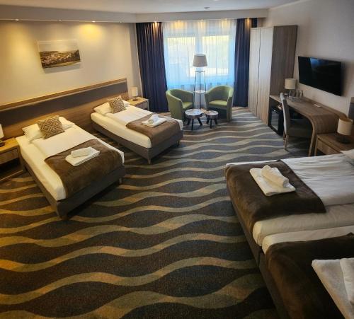 a hotel room with two beds and a couch at Hotel Bardo in Bardo