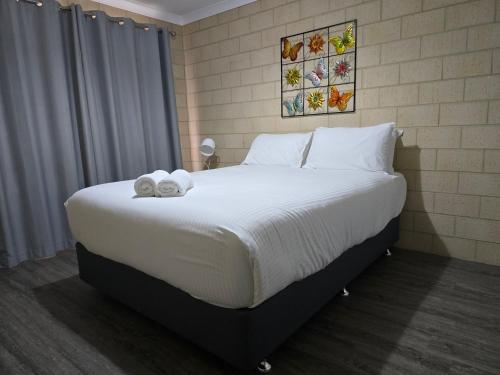 a bedroom with a large bed with towels on it at Esperance Break Away in Esperance