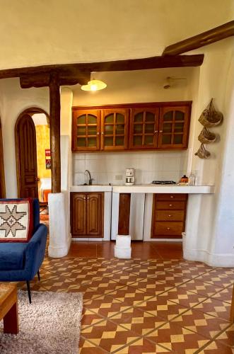 a kitchen with wooden cabinets and a blue couch at INTIYAYA - Boutique Lodge in Otavalo