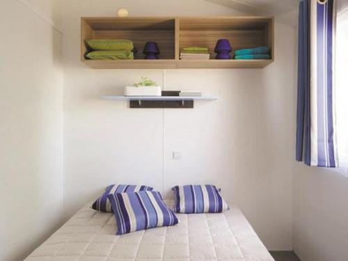 two pillows on a bed in a room at Mobil-home cosy avec terrasse à Avrillé - API-1-52-490 in Avrillé