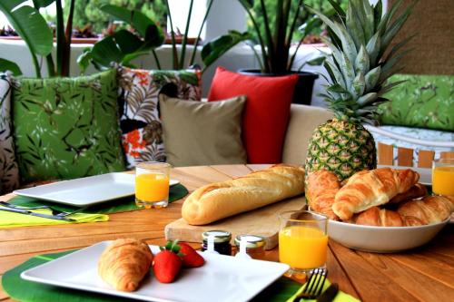 a table with croissants and a bowl of bread and fruit at Botanic Home in Marbella