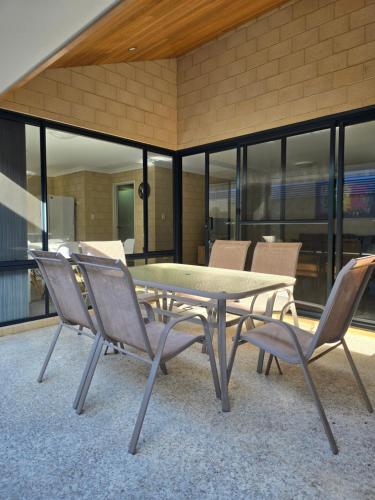 a table and chairs in a room with windows at Esperance Break Away in Esperance
