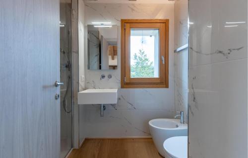 a white bathroom with a sink and a mirror at Lovely Home In Passo Del Cerreto in Cerreto Laghi