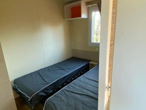 a small room with a bed and a window at Mobil-home cosy avec terrasse pour 2 personnes - API-1-52-575 in Le Fouilloux