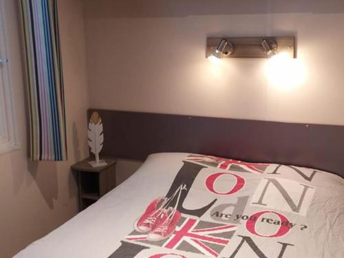 een slaapkamer met een bed met een bordje erop bij Mobil-home avec Terrasse - 2 Chambres - API-1-52-552 in Saint-Maime