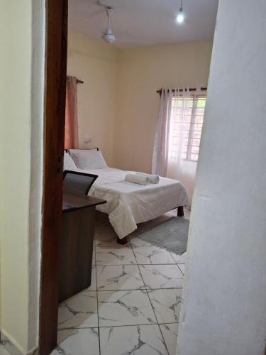 a small room with a bed and a window at Zai Homes Watamu in Watamu