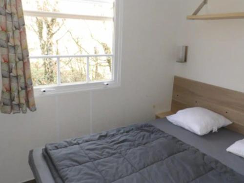 une chambre avec un lit et une fenêtre dans l'établissement Mobil home confortable avec terrasse et équipement complet - API-1-52-601, à Limeuil