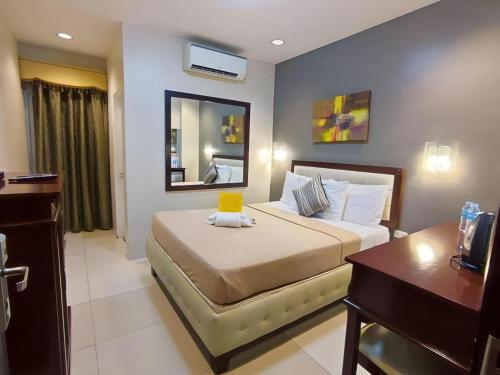 a bedroom with a bed with a desk and a mirror at Devera Hotel in Angeles