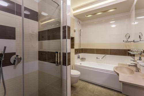 a bathroom with a sink and a toilet and a tub at New Splendid Hotel & Spa - Adults Only (+16) in Mamaia