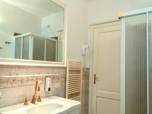 Un baño con lavabo, espejo y ducha. en Holiday Home near Assisi with Pool, en Asís