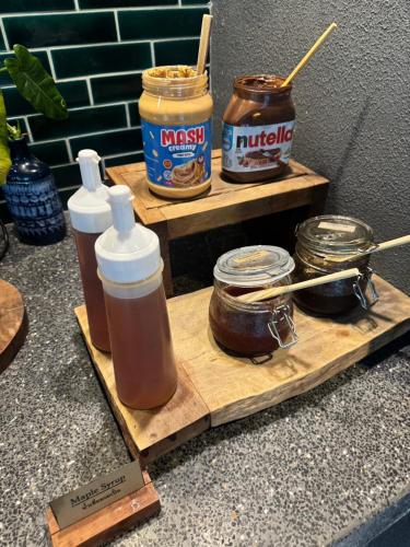 a wooden cutting board with jars of honey and peanut butter at Seamira House Huahin in Hua Hin