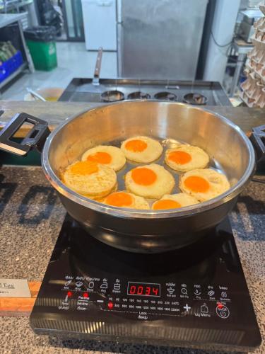 a pan of eggs cooking on top of a stove at Seamira House Huahin in Hua Hin