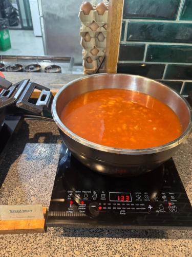 a pot of soup in a pan on a stove at Seamira House Huahin in Hua Hin