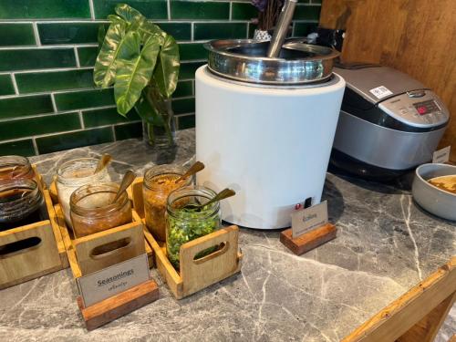 a counter with a coffee maker and jars on it at Seamira House Huahin in Hua Hin