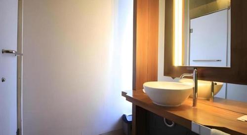 a bathroom with a white sink and a mirror at Griya Jogja Hotel in Yogyakarta