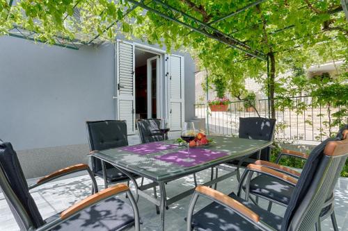 a table and chairs on a patio at Apartments Lidija - sea view apartment with exclusive right of using hot tub or split level apartment with exclusive right of using pool in Podstrana