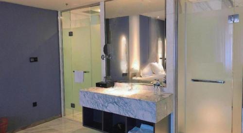 a bathroom with a sink and a large mirror at Harbin Splendent Hotel in Harbin