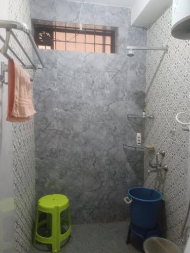 a shower with a green stool in a bathroom at Sirigandha Farms, Near Jog Falls in Talguppa