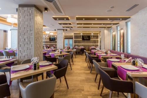 a dining room with tables and chairs in a restaurant at New Splendid Hotel & Spa - Adults Only (+16) in Mamaia
