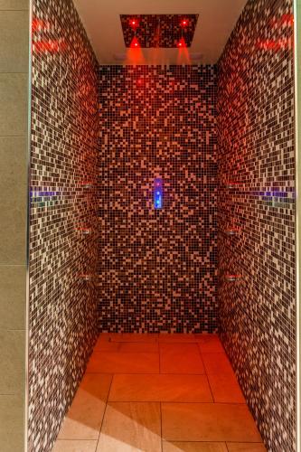 a bathroom with a brick wall with a blue light at New Splendid Hotel & Spa - Adults Only (+16) in Mamaia