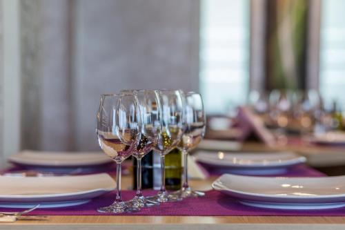 a table with wine glasses and plates on a table at New Splendid Hotel & Spa - Adults Only (+16) in Mamaia