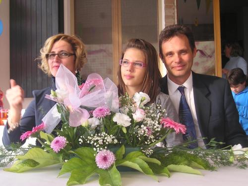 three people sitting at a table with a bouquet of flowers at Agriturismo Le Essenze - Terrazza sulla Romagna in Cesena
