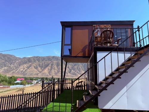 a stairway to a house with mountains in the background at Opensky-kolsai in Saty