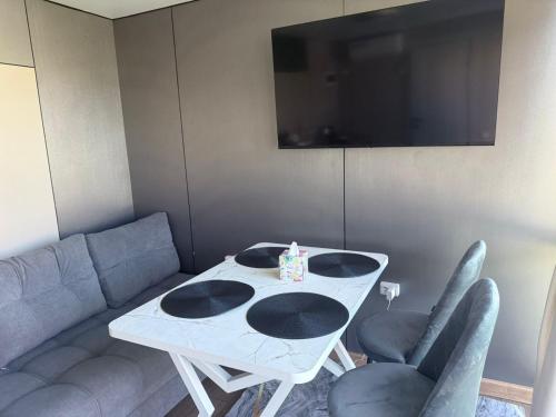 a room with a table and a couch and a television at Opensky-kolsai in Saty