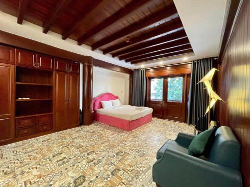 a bedroom with a bed and a couch in a room at GemVilla 188 Large pool garden in Ho Chi Minh City