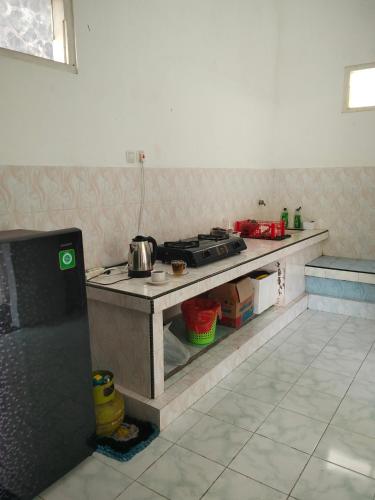a kitchen with a stove and a counter top at Cozy Corner House in Banyuwangi