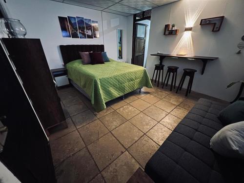a bedroom with a bed and a table with stools at Hidden House in Antigua Guatemala
