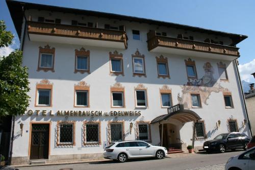a building with a car parked in front of it at Hotel garni Almenrausch und Edelweiss in Garmisch-Partenkirchen