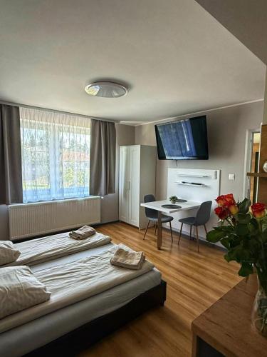a hotel room with a bed and a table and a dining room at Garden Apartments in Kráľovský Chlmec