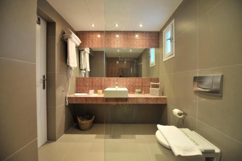 a bathroom with a sink and a mirror at Almira Suites - Seafront - Naousa Paros in Naousa