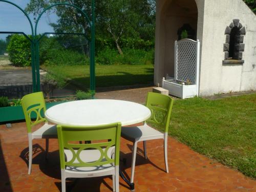 a table and four chairs on a patio at Logis La Rose Des Vents in Volvic