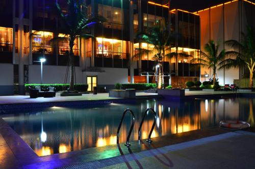 - une piscine en face d'un bâtiment la nuit dans l'établissement Fleuve Congo Hotel By Blazon Hotels, à Kinshasa
