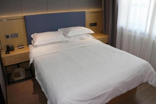 a large white bed in a hotel room at Green Tree Inn Urumqi San'gong Metro Station Exit in Ürümqi