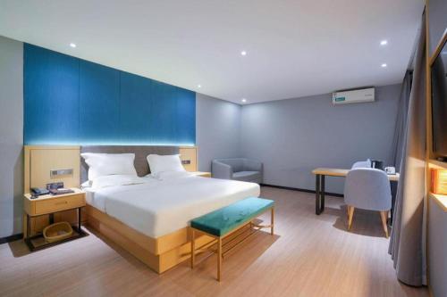 a hotel room with a bed and a desk and a chair at Green Tree Inn Urumqi San'gong Metro Station Exit in Ürümqi