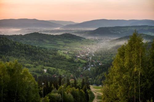 a view of a valley with trees and a town at Apartamenty przy Hotelu Żywieckim in Przyłęków